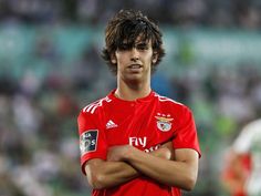 a soccer player standing with his arms crossed