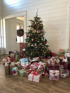 a christmas tree is surrounded by presents on the floor