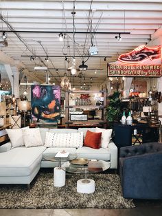 a living room filled with furniture and lots of lights hanging from the ceiling above it