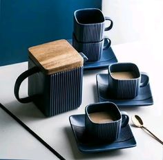 three coffee cups and two spoons on a table