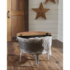 an old barrel turned into a coffee table in the corner of a room with wooden stars on the wall