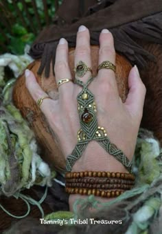 a woman's hand with bracelets and rings on it