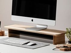 an apple computer sitting on top of a desk next to a keyboard and mouse pad