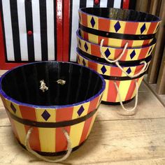 four colorful buckets sitting on top of a wooden table