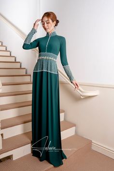 This exquisite ao dai is expertly designed with a traditional collar and floor-length silhouette, showcasing its rich moss green hue. Crafted from luxurious fabric, it also comes with a pair of black pants, making it perfect for any formal occasion. Let this timeless piece elevate your wardrobe with its elegant and sophisticated appeal. Traditional Green Long Sleeve Maxi Dress, Traditional Long Sleeve Green Maxi Dress, Elegant Evening Green Abaya, Elegant Green Evening Abaya, Fitted Green Dress For Eid, Traditional Full-length Green Dress, Traditional Full Length Green Dress, Elegant Green Maxi Length Abaya, Traditional Green Ao Dai For Festive Season