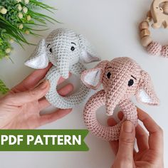 two crocheted elephants are being held by someone's hands with flowers in the background