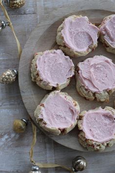 several cookies with pink frosting on a plate