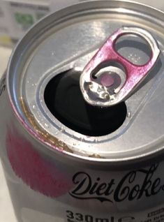 an open can of diet coke with pink paint on it's lid and the top half missing