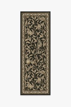 an intricately designed rug with flowers and leaves in black, beige and gold colors