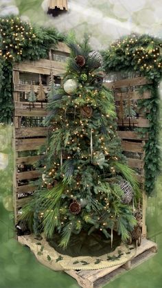 a christmas tree in a wooden crate surrounded by greenery