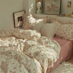 an unmade bed in a bedroom with pink comforter and pillows on the floor