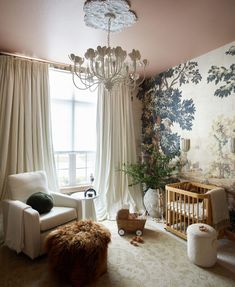 a baby's room with a chandelier, chair and crib in it