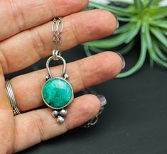 This pendant features a really pretty Chrysocolla in Quartz. It's got this great aqua blue green color. Flip the pendant over and I have textured the metal with a pattern that mimics the pattern in the stone. The piece is just over 3/4 inches wide and 1 1/2 inches long ♦Chain: This comes on a oval link chain that is currently 18-20 inches. It has a lobster claw clasp and 2 inch extension chain. If you would like to adjust this length please send me a message. ♦ Metal: Sterling silver and fine si Chrysocolla Gemstone Teardrop Necklace, Handmade Chrysocolla Oval Pendant Jewelry, Green Chrysocolla Jewelry With Large Pendant, Chrysocolla Gemstone Oval Pendant Jewelry, Green Chrysocolla Pendant Jewelry, Long Chain, Quartz Pendant, Silver Pendant Necklace, Silver Turquoise