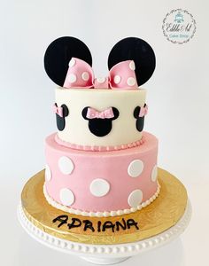 a pink and white cake decorated with minnie mouse ears