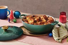 a green casserole dish filled with food on a table next to other dishes