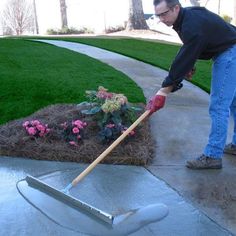 a man is shoveling dirt into a flower bed