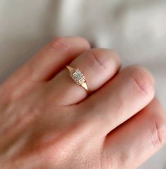 a woman's hand with a diamond ring on it