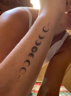 a woman with a tattoo on her arm that reads,'i love you to the moon and back '