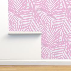 a pink and white palm leaf wallpaper in a room with wood flooring next to it