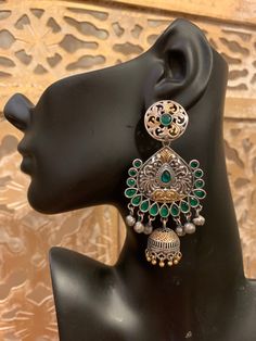 Gorgeous chandbali-jhumka design in pure brass (90%) and pure silver (10%) in two tone / dual tone / silver gold finish. Very beautiful design and craftsmanship. Available in red, blue, green, clear and multicolor stones. Care Instruction: Avoid heat & substances like perfume, deodorant, alcohol, etc and clean with silver/gold polish cloth. Store in airtight spaces like ziplock pouch or jewelry box. Dual-tone Chandbali Temple Danglers, Fusion Style Dual-tone Chandbali Jhumkas, Fusion Style Chandbali Brass Jhumkas, Dual-tone Chandbali Fusion Danglers, Silver Dual-tone Chandbalis For Diwali, Dual-tone Fusion Chandbali Danglers, Sterling Silver Chandbali Jhumkas Temple Jewelry, Silver Dual-tone Chandbalis For Festivals, Sterling Silver Chandbali Jhumkas For Festivals