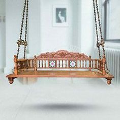 a wooden swing hanging from the ceiling in a room with white walls and flooring