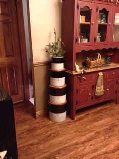 a red china cabinet sitting in the corner of a living room next to a wooden floor