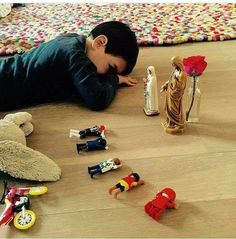 a little boy laying on the floor with toys