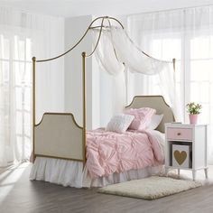 a white and pink bedroom with four poster bed, dressers, and nightstands