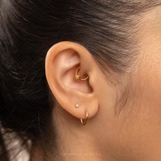 a close up of a person's ear with a gold nose ring on it