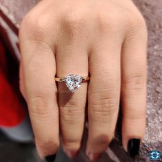 a close up of a person's hand with a diamond ring on their finger