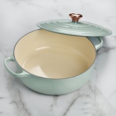 two green pots sitting on top of a marble counter