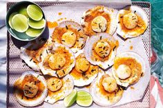 an overhead view of some scallops and limes on a tray