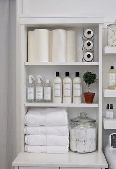 a bathroom shelf filled with lots of white towels and toiletries on top of it