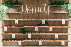 a display case filled with lots of donuts and cupcakes on top of wooden shelves