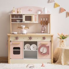 a toy kitchen with pink and white appliances