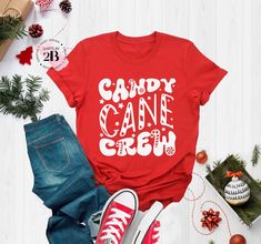 Candy Cane Crew Shirts, Christmas Groovy T-Shirt, Christmas Squad Gift, Christmas Season Tee, Christmas Gift, Matching Christmas Shirt Hello!! We wish everyone to smile with our cute, stylish, and trendy graphic shirts. We assure you these shirts are the perfect gifts whether you buy them for yourself or someone else. Please, check the size chart before you purchase from our display pictures HOW TO MAKE AN ORDER *Pick your shirt type and size Your design will be printed on the front. *Pick your shirt color PRODUCTION Processing time is 1-3 business days. For rush orders please contact us first. SHIPPING Domestic Shipping First Class 2-5 Business days Priority Mail 1-3 Business days Express Mail 1-2 Business days MATERIAL CARE Turn inside out. Cold Wash Do not bleach, dry clean, or iron dir Candy Cane Day At School Outfits, Candy Cane Christmas Pajamas, Candy Cane Pajamas, Candy Cane Vinyl Shirt, Santa Bingo, Candy Land Shirts Tees, Candy Cane Shirt, Matching Christmas Shirts, Display Pictures