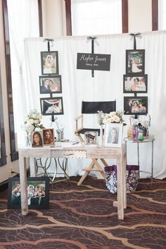 a table with pictures and photos on it in front of a white curtained wall