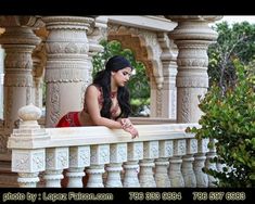 a woman in a red dress sitting on a balcony