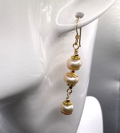 Unique presentation of peach freshwater pearls, antique gold spacers, and filigree bead caps in these elegant dangle earrings. The dangles are connected to each other and to the gold filled earwire through gold filled wrapped loops.  The earrings are about 1 1/4 inches long, measured from the earwire, and come nestled comfortably on a bed of cotton in a white cardboard box. Made in the USA by me. NA-821-0624-1111 Gold Pearl Bead Earrings For Formal Events, Handmade Gold Pearl Earrings With Round Beads, Gold Pearl Earrings With Round Beads For Formal Occasions, Elegant Gold Beaded Pearl Earrings, Handmade Gold Pearl Earrings, Gold Earrings With Pearl Drop And Round Beads, Gold Earrings With Pearl Drop, Delicate Gold Earrings With Dangling Beads, Gold Pearl Earrings With Round Beads