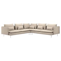 a large sectional couch with pillows on it's back and arms, facing the camera