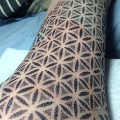 a close up of a person's arm with tattoos on it and an intricate design