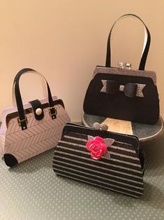 three purses sitting next to each other on a table