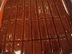 chocolate bars are lined up in rows on the trays for sale at a store