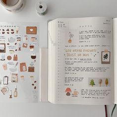 an open notebook with stickers and tape on the pages, next to a cup of coffee