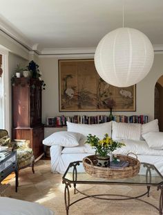 a living room filled with furniture and a large white ball hanging over the top of it