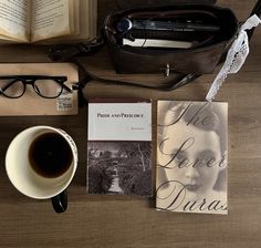 there is a book, glasses, coffee and other items on the table next to it