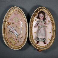 two antique dolls in oval frames with gold trim