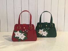 two purses sitting on top of a table next to each other with flowers painted on them