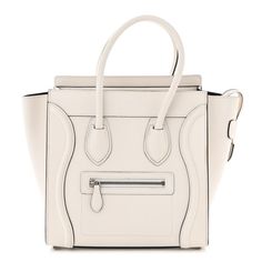 This is an authentic CELINE Smooth Calfskin Micro Luggage in White. This feminine tote is crafted of smooth calfskin leather in white with black trimmed edges. It features rolled top handles, silver hardware, and winged sides, and an exterior zip pocket. The top zips open to a black leather interior with zipper and patch pockets. White Calf Leather Bag With Silver-tone Hardware, White Classic Calf Leather Bag, Classic White Calf Leather Bag, White Calf Leather Tote Bag, White Top Handle Bag With Leather Lining, Luxury White Bags With Leather Lining, White Smooth Grain Bag For Shopping, White Smooth Grain Shopping Bag, Modern White Bag With Leather Lining