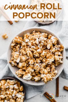 two bowls filled with cinnamon roll popcorn on top of a white cloth next to cinnamon sticks